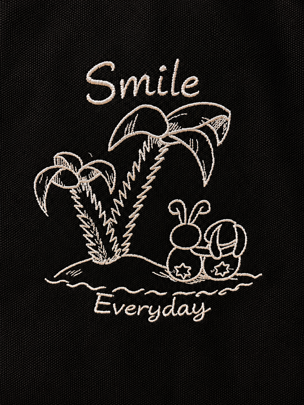 Gesticktes Smile Everyday Motiv mit Palmen auf schwarzer Canvas Tasche.